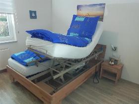 Doppelbett mit hochgefahrerem Pflegebetteinsatz